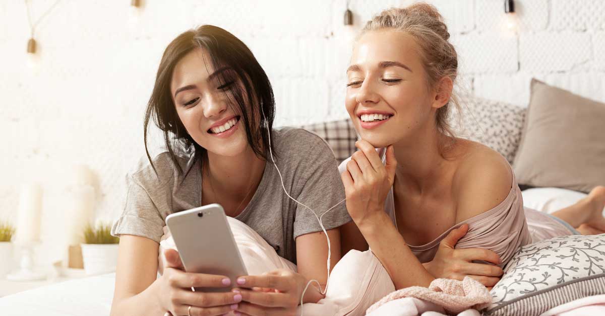 two girls smiling while texting